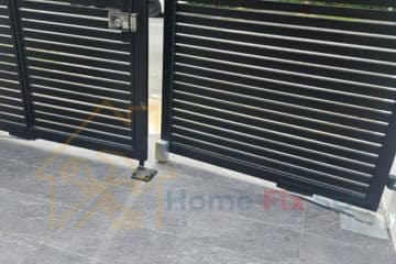 A black modern automated swing gate installed at a residential driveway by Home Fix SG in Singapore.