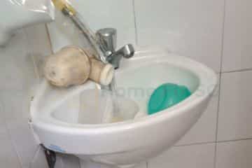 A clogged and dirty bathroom wash basin before professional cleaning and repair service by Home Fix SG in Singapore.